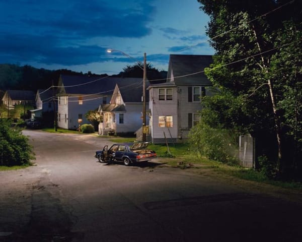 Gregory Crewdson photograph of a car with a popped trunk on suburban street