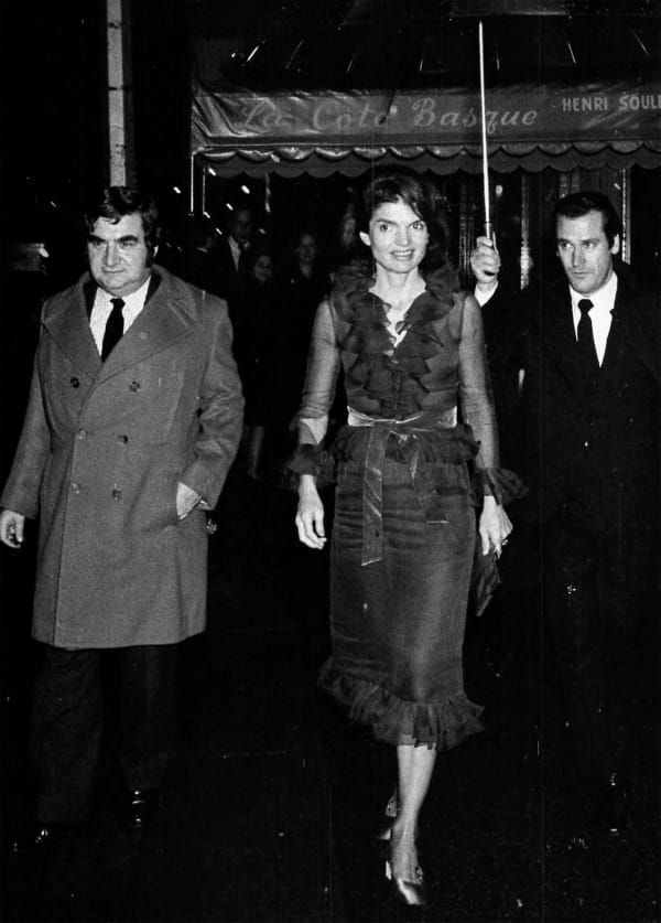 Ron Galella, Jackie at La Cote Basque Restaurant with chauffeur carrying umbrella, November 14, 1970