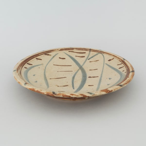 A Winchcombe Pottery plate with vumé lily motif