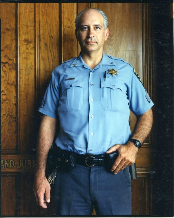 Bruce Wrighton Court officer in blue uniform, in front of Grand Jury door Tirage C-print d'époque 20 x 25 cm Dim. papier: 20 x 25 cm