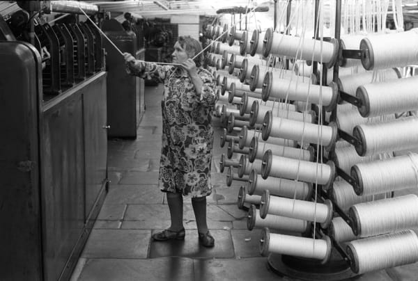 Homer Sykes, Factory work, woman working in Salts Mill Saltaire Yorkshire, 1981