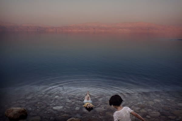 Paolo Pellegrin, Palestinian girls floating on the waters of the Dead Sea. West Bank, 2009