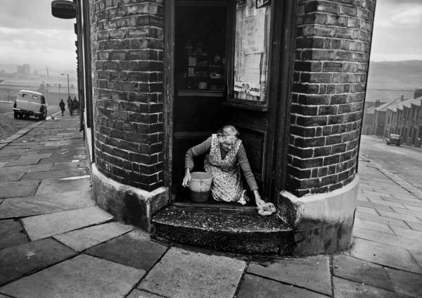 Colin Jones, A shopkeeper washing her doorstep, Benwell, Newcastle-upon-Tyne, 1963