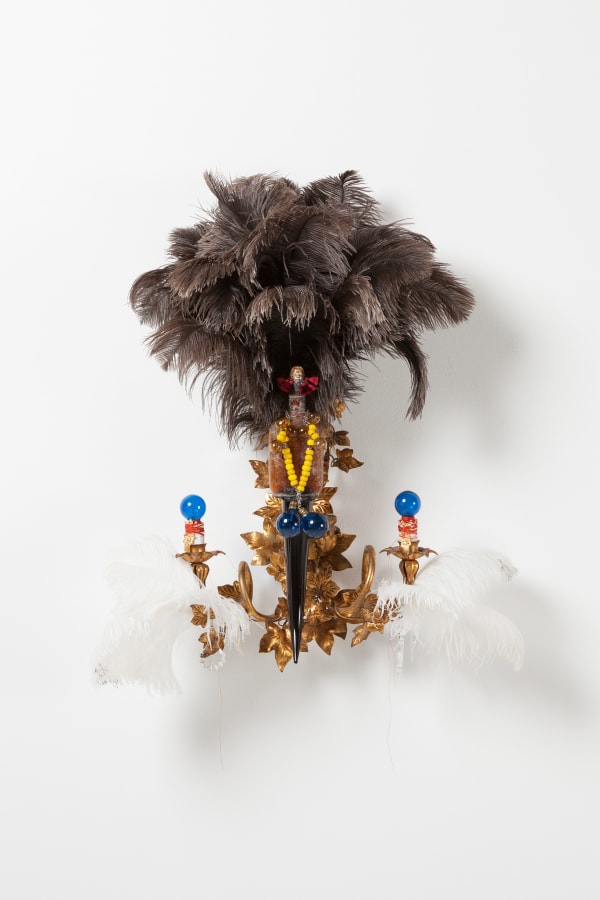 Rina Banerjee Sex-bait, in likeness to fish bait to catch her as disloyalty in likeness to Eve, to arouse her fear, to create racial panic of black jewels like honey to stir and stir poisonous passions, minted money out lynching funny, 2017 Antique Italian-American sconce, Murano glass black horn, African handmade glass beads, German porcelain Victorian negro head, Ostrich feather duster (black), Ostrich feathers (white), Murano, glass beads 91 x 56 x 32.5 cm
