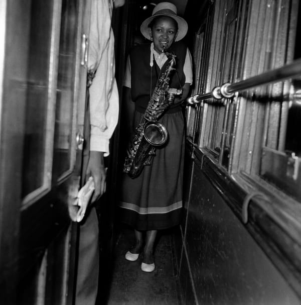 Bob Gosani, Dolly Rathebe with saxophone on train to Durban, c.1955, printed 2025