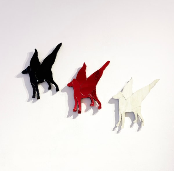 Three winged ceramics pegasus' in black, red and white created by eccentric British sculptor Andrew Logan.
