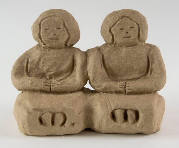 A sculpture of two figures sat side by side by artist Reniel Del Rosario.