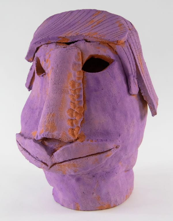 A sculpture of a purple mask with two sets of lips by artist Reniel Del Rosario.