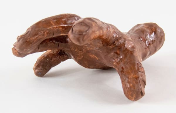 A clay sculpture of a hand with fingers spread to gesture reaching out by artist Reniel Del Rosario.