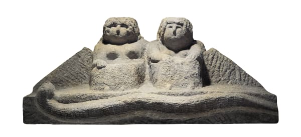 Simple sculpture of a man and a women sitting together on a platform.
