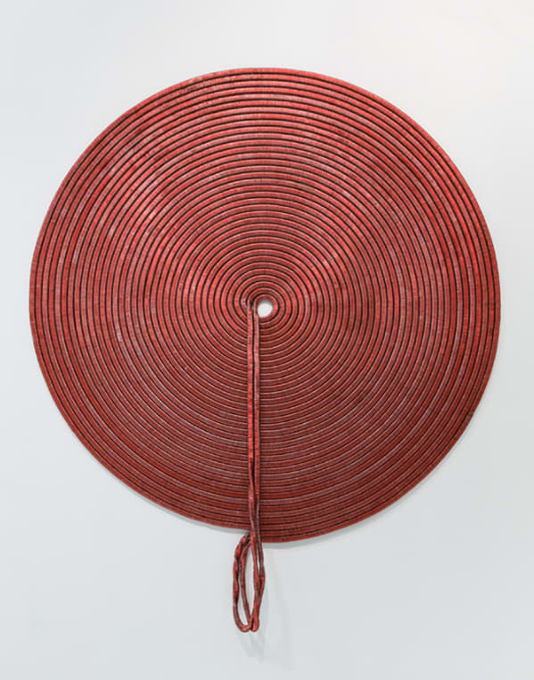 Large red spiral with something hanging from the middle.