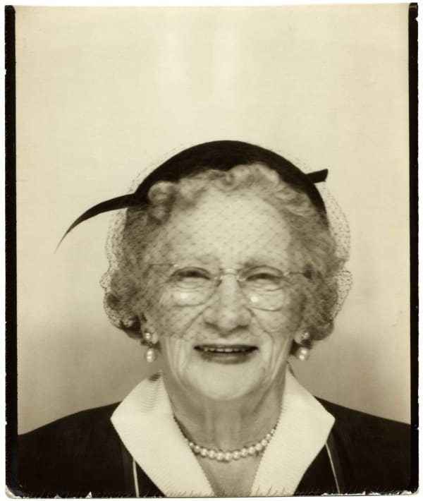 ENLARGEMENT REPRINT Vernacular, Untitled (Dealer title: "Feathered Hat" - photobooth - Woman, glasses, hat) Silver Gelatin Print