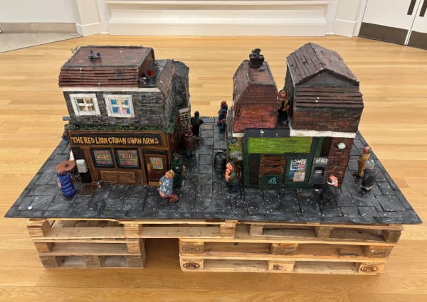 Niamh Finnigan Doontoon, 2025 Mixed media sculpture: buff and air-dry clay, MDF board, acrylic paint, cardboard, oil pastel, laminate sheets, pen, pencil, paper, glue, varnish, scrap materials, wooden pallets 121 x 200 x 100 cm