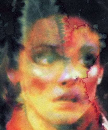 A blurry close-up of a white person's face, with brown hair, dark eyes looking off frame at right, parted lips, and a red collar. The entire surface is altered by watery stains, which render most of the person's face yellow with red feathering and spread translucent grayish-green across the left side of their forehead and hairline. Granular spots of red below their cheekbones look like heavy blush, and white flares on cheekbones, nose, and right earlobe look like misplaced highlights.