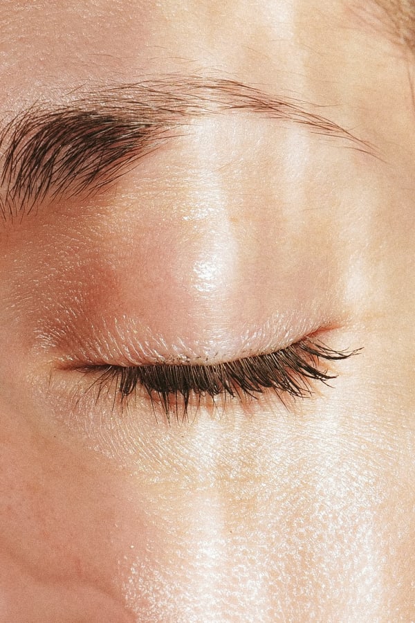 Photograph by Casey Joiner of one close up closed eye in partial sun.