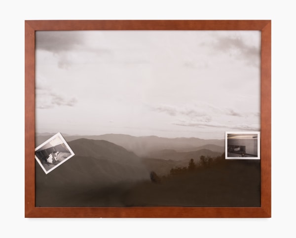 A black and white photograph by Mark Anthony Brown Jr. of a black and white wooded mountain landscape. Tucked into the edge of the brown frame are two smaller black and white found photographs.