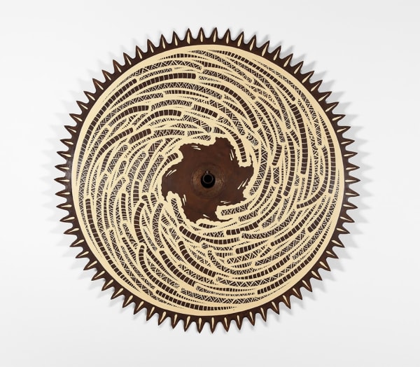 photograph of a vintage saw blade decorated with swirling geometric designs