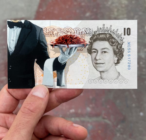 waiter holding a plate with worms drawn on top of english currency