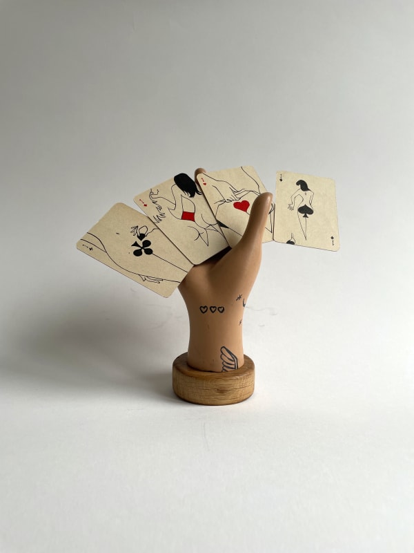 sculpture of hand holding four playing cards