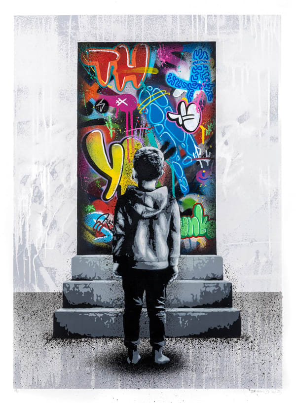 a boy in black and white standing in front of a door decorate with colorful graffitti