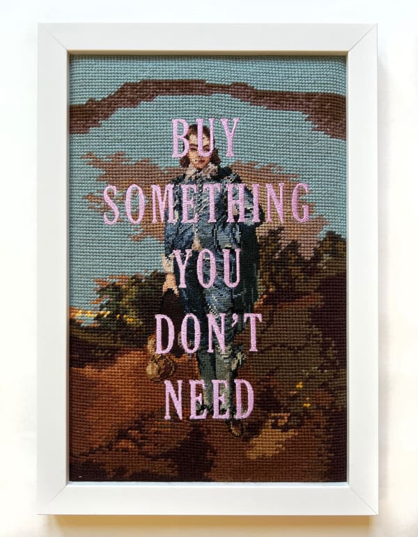 embroidery on needle-point reading "Buy Something You Don't Need"