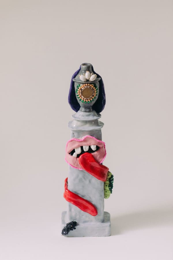 Marian Bull sculpture of a gravestone with a mouth and tongue winding around the pillar