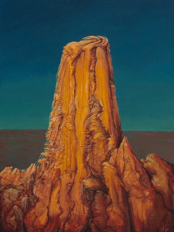 vertical rock formation with a blue sky background