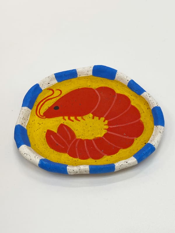 Jackie Brown ceramic plate of shrimp on yellow background with blue and white striped border