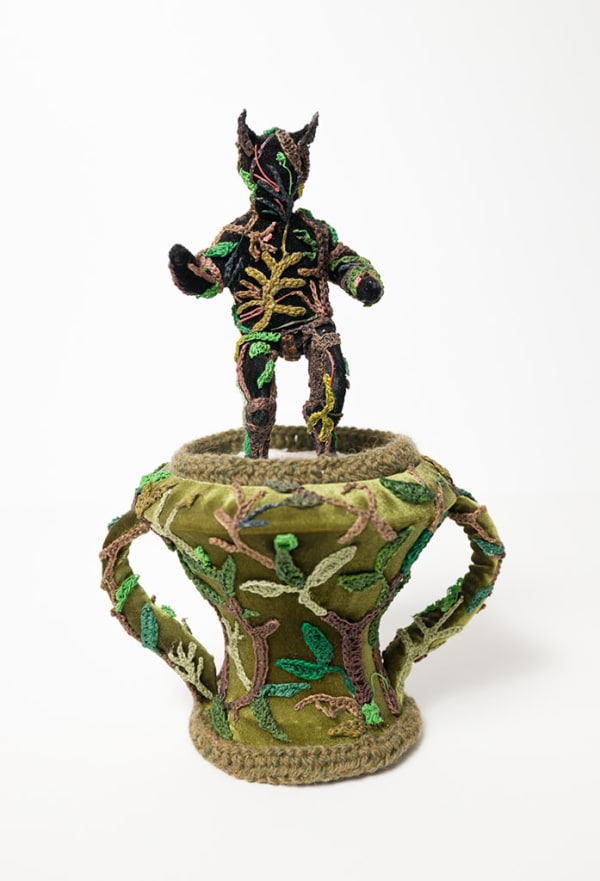 crocheted thread sculpture of a human figure on a vase