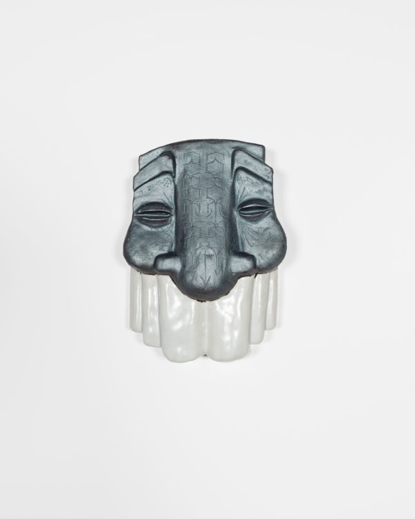 sculptural mask with a metallic grey top and white bottom