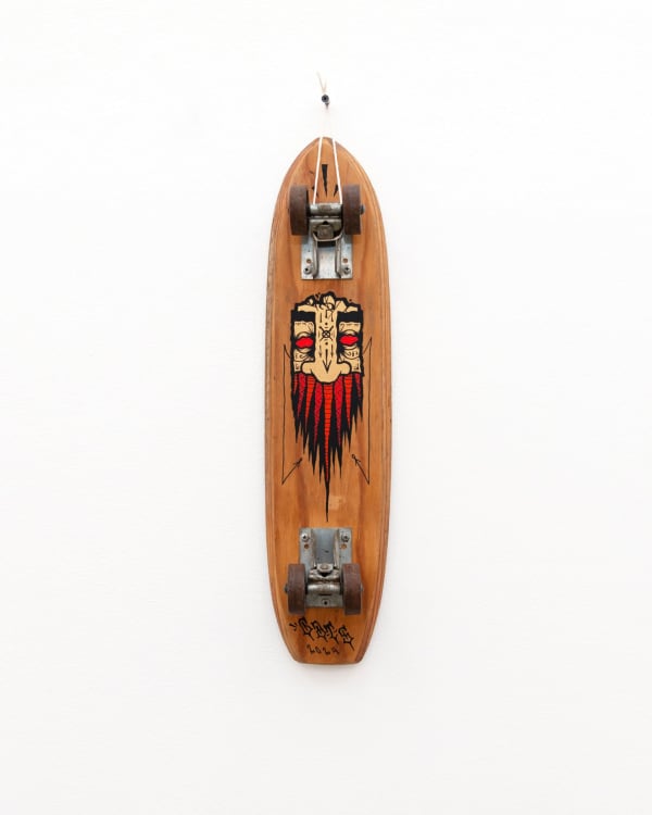 Brown wooden vintage skateboard with a light brown and red beard GATS character painted on the bottom of the board