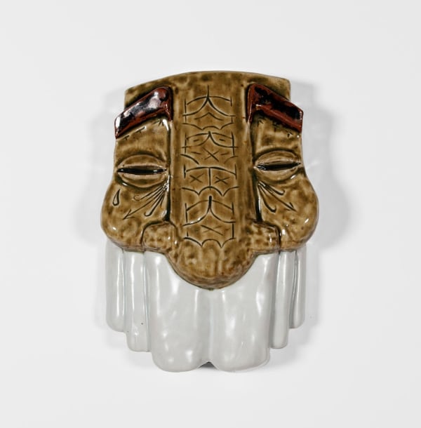 sculptural mask with a light brown textured top and a white bottom