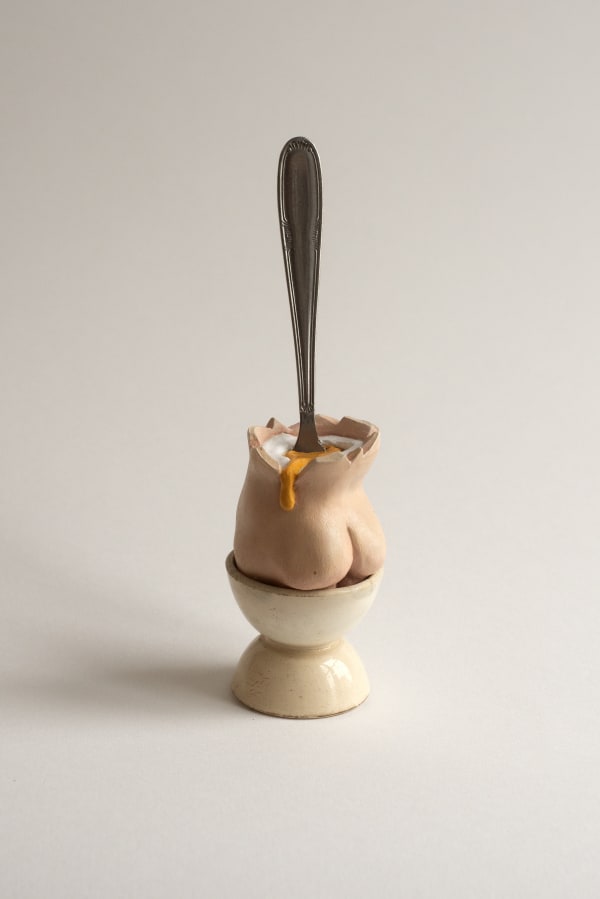 sculpture of a spoon inside of a cup shaped like a butt