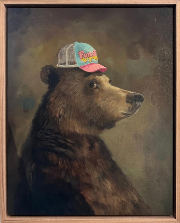 A painting of a brown bear wearing a blue and pink baseball hat.