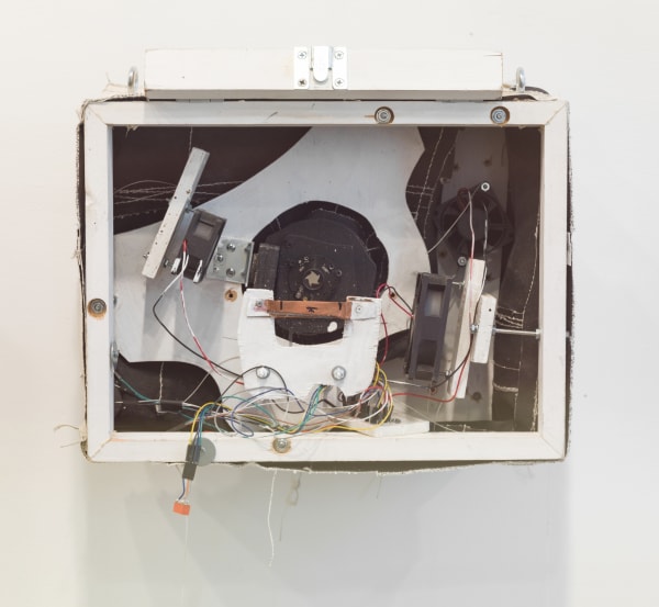 White rectangular sculpture with black designs and wiring inside