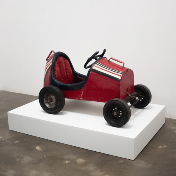 Red child-sized car made of tin and wood