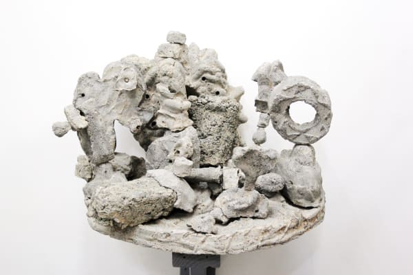 many small concrete figurines on a disk