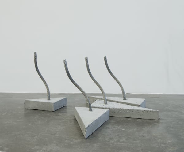 Four triangular concrete bases with curved wire rope inserted