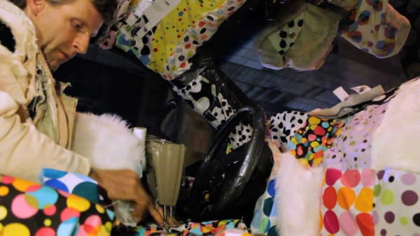 Male figure in a chaotic space with colorful childrens linens