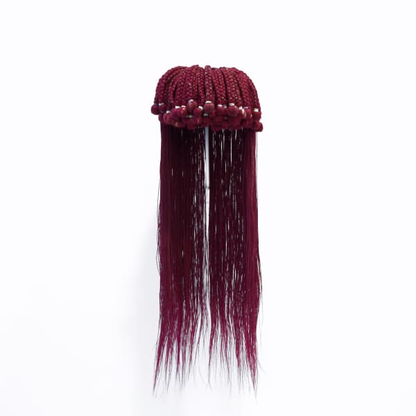 Sculpture made of red synthetic hair with braided bangs tied with colored rubber bands