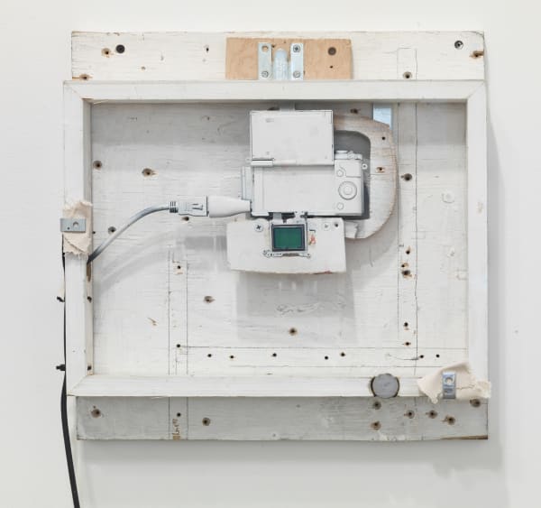 Abstract white rectangular sculpture with black wire coming out of the side