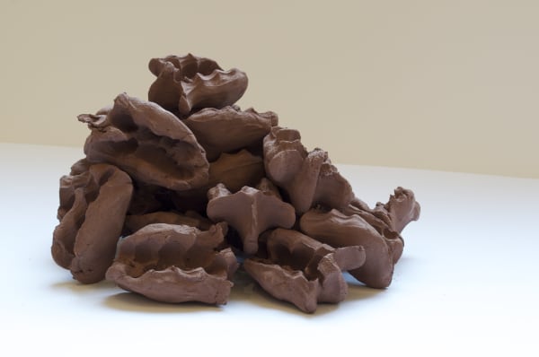 Terracotta sculpture of a pile of brown abstract oval shapes