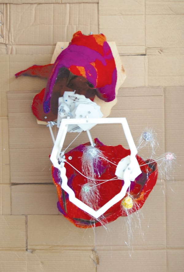 Red and white abstract sculpture with fuzzy spheres