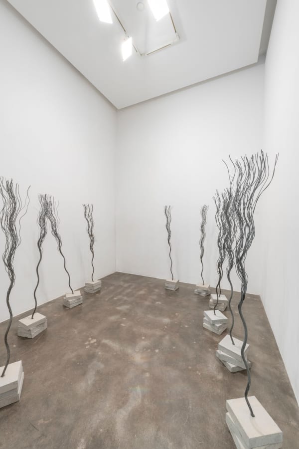 Wire rope twisted to look like trees embedded in stacked concrete bases