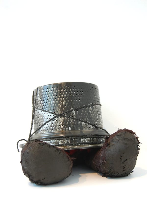 Black bucket with two toy feet sticking out from underneath