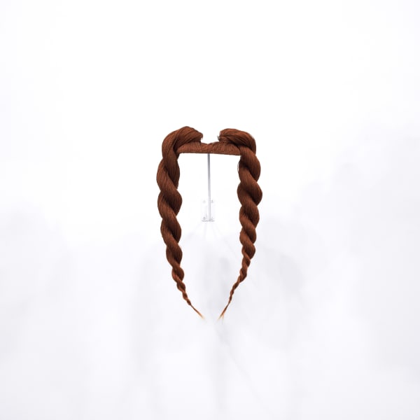 Sculpture of reddish brown synthetic hair styled with two top knot braids