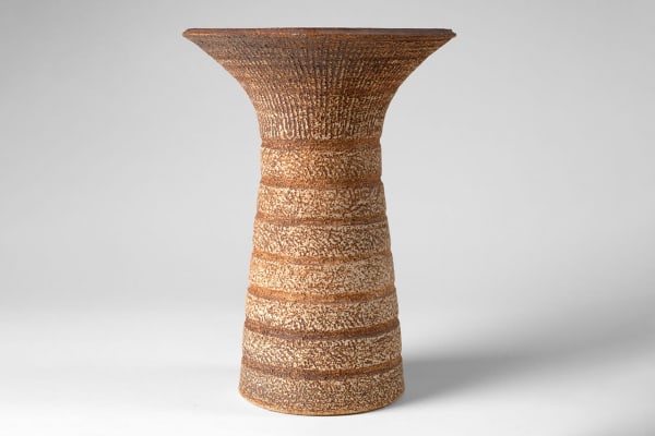Waistel Cooper Tall trumpet vase, late 1960s-1970 decorated with an incised lip and carved horizontal bands, on a rust and cream textured surface signed ‘Waistel’ to the base Culbone stoneware 12 ½ x 9 ½ inches