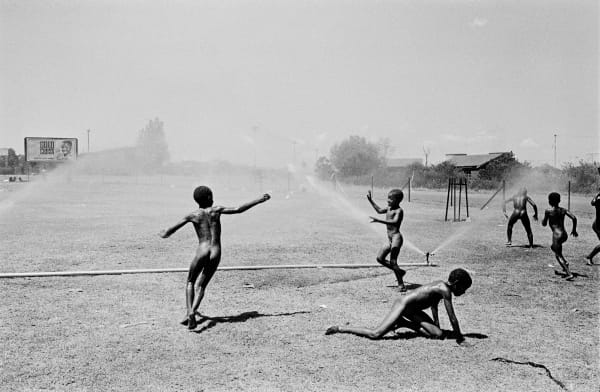 Ernest Cole, Children play with Sprinklers, circa 1965