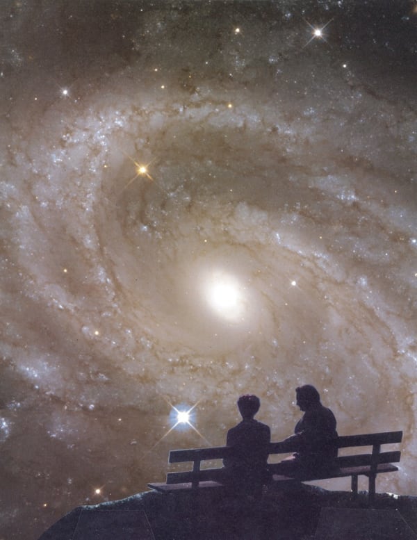 Image of two people on bench looking at solar system