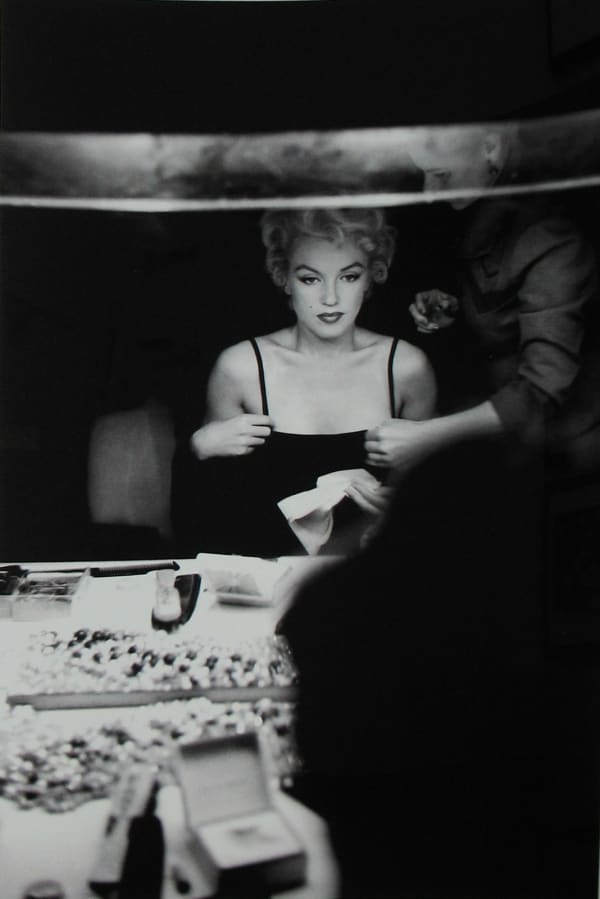 Marilyn Monroe looking at her makeup in the dressing room mirror of Carol Haney in New York City, 1954